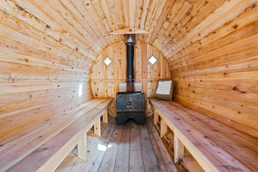 Salle de sauna avec cuisinière et bancs en bois.