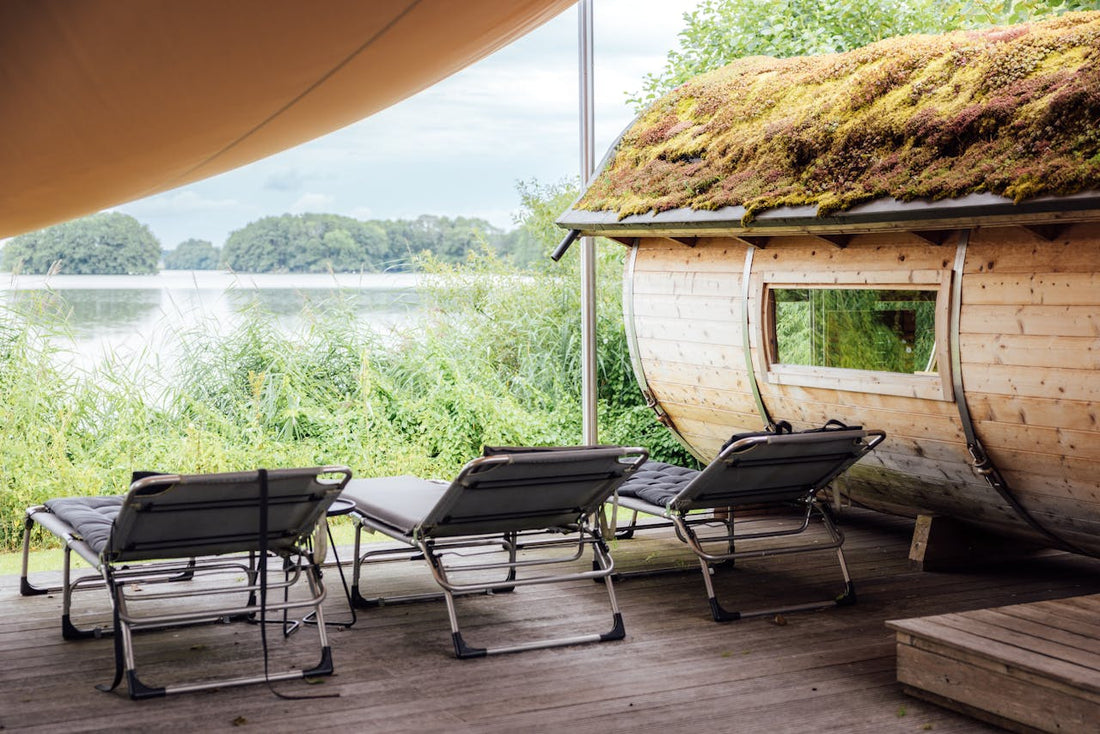 Chaises sur une terrasse en bois à côté d'un sauna.