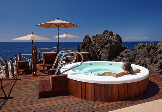 Femme dans le jacuzzi avec vue sur l'océan.