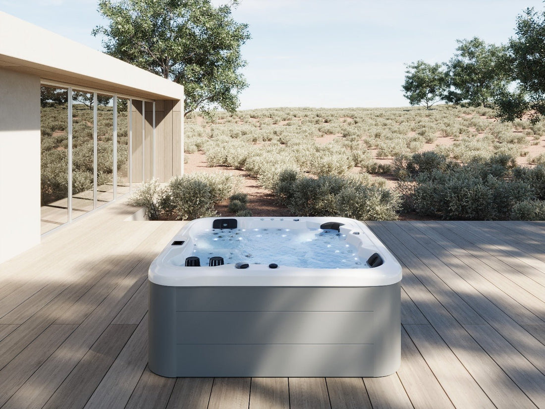 Baignoire d'hydromassage éclairée sur une terrasse extérieure.