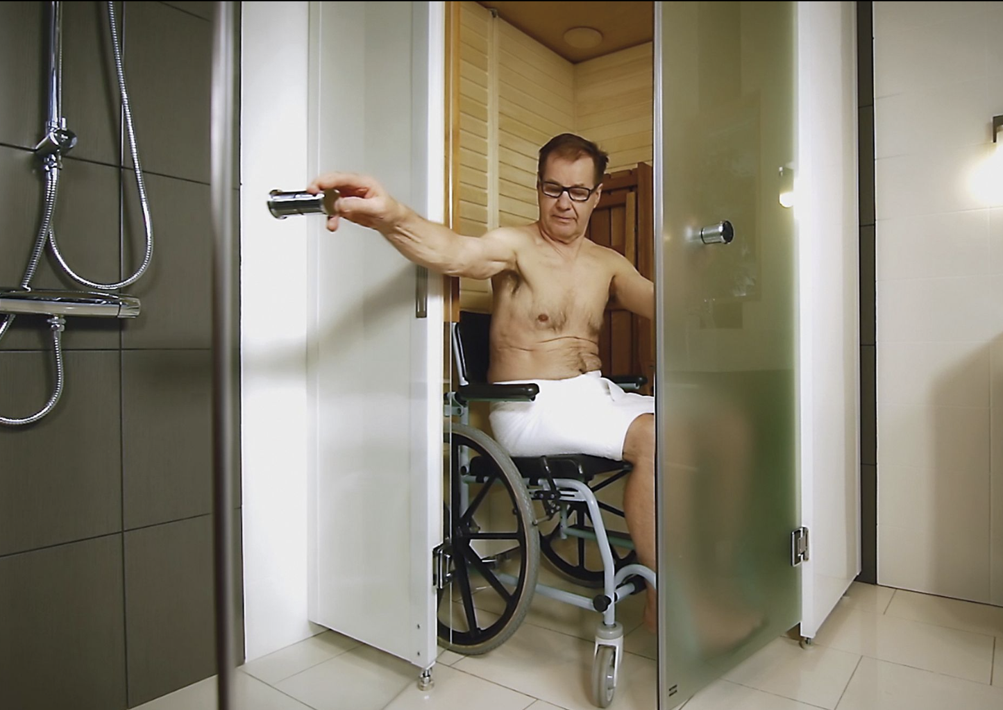 Un homme en fauteuil roulant utilisant le sauna SmartFold.