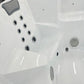 Jacuzzi extérieur Hydra 215 avec siège gris et jets visibles.