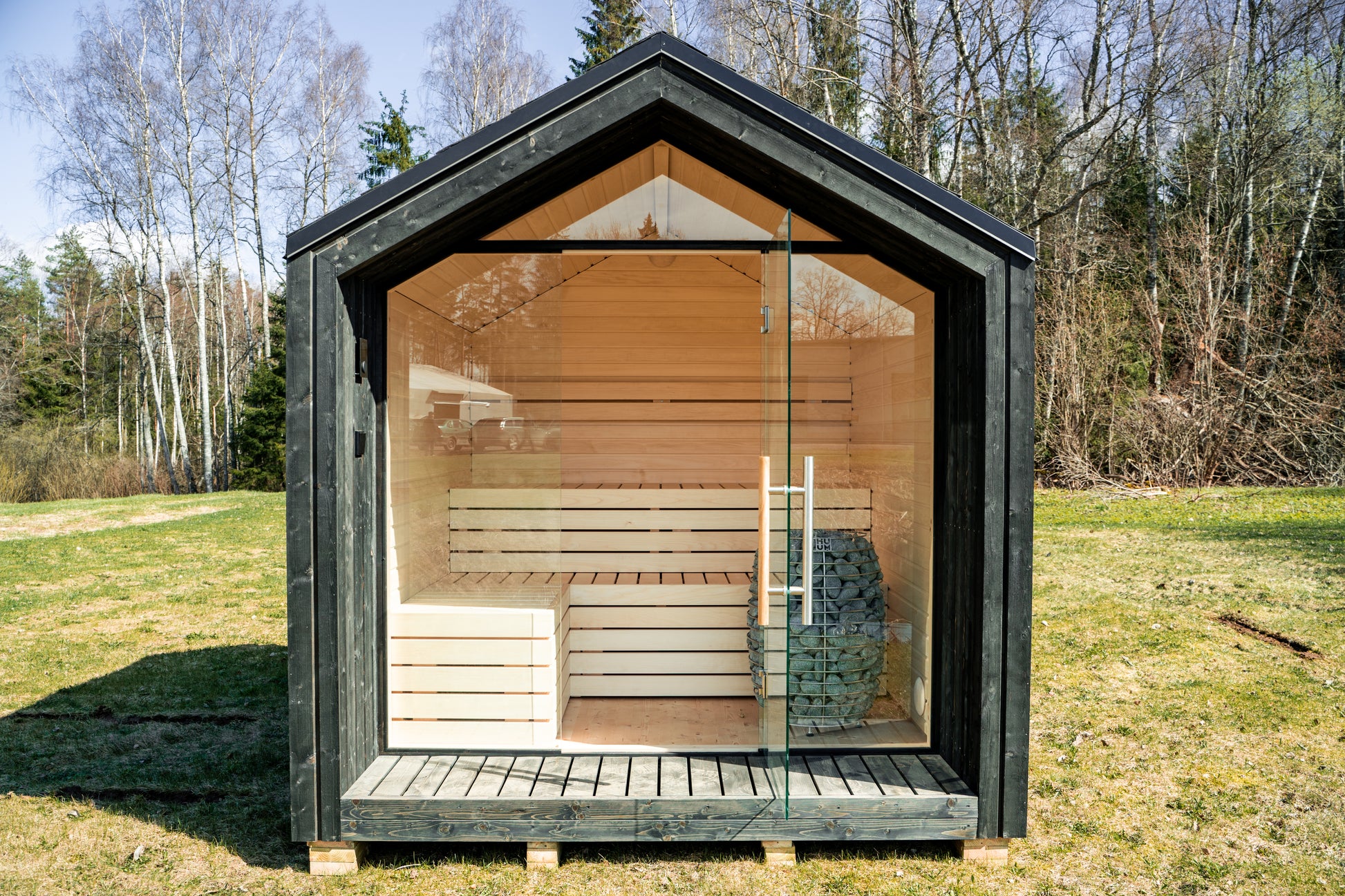 Saunamo Sauna extérieur isolé Lumi dans une zone herbeuse.