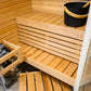 Sauna Sirius Corner avec bancs en bois et seau noir.