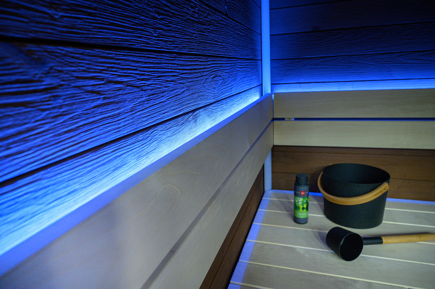 Sauna en bloc avec éclairage LED et seau noir.