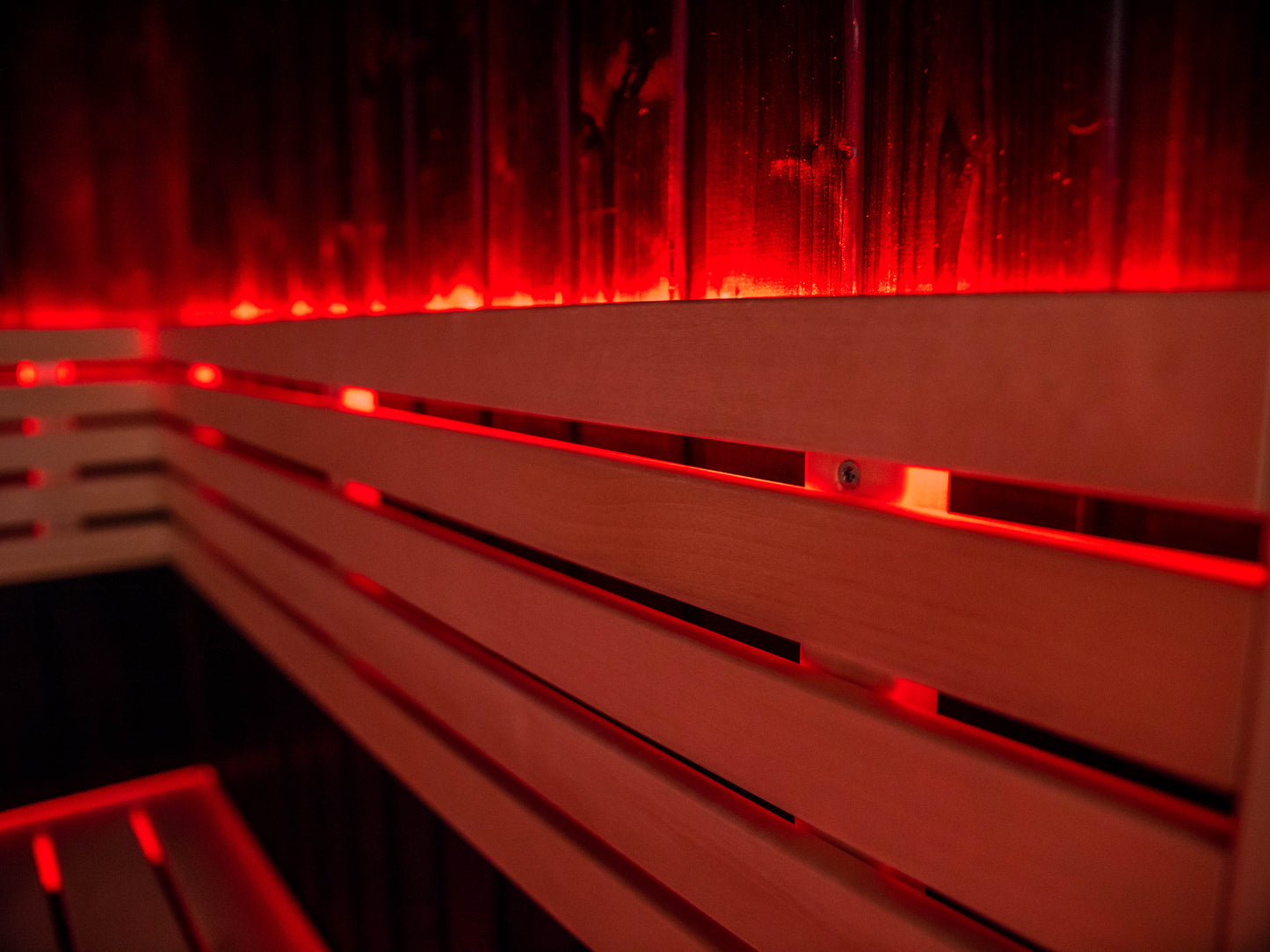 Sauna Fenix avec lumière LED rouge sur banc en bois.