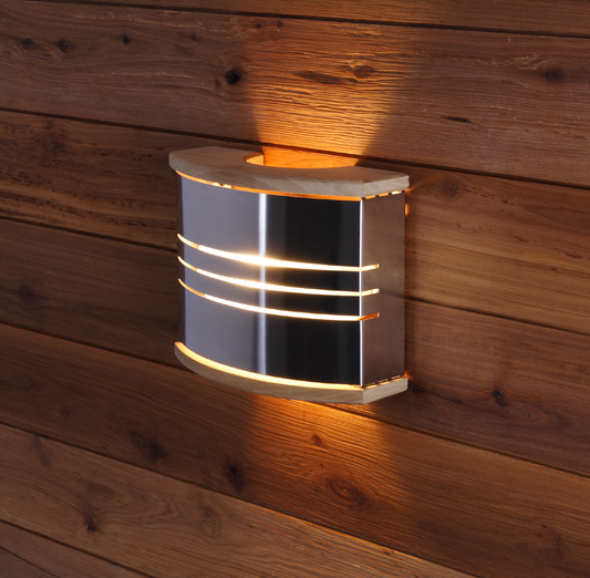 Lampe de sauna en acier Harvia sur un mur en bois.