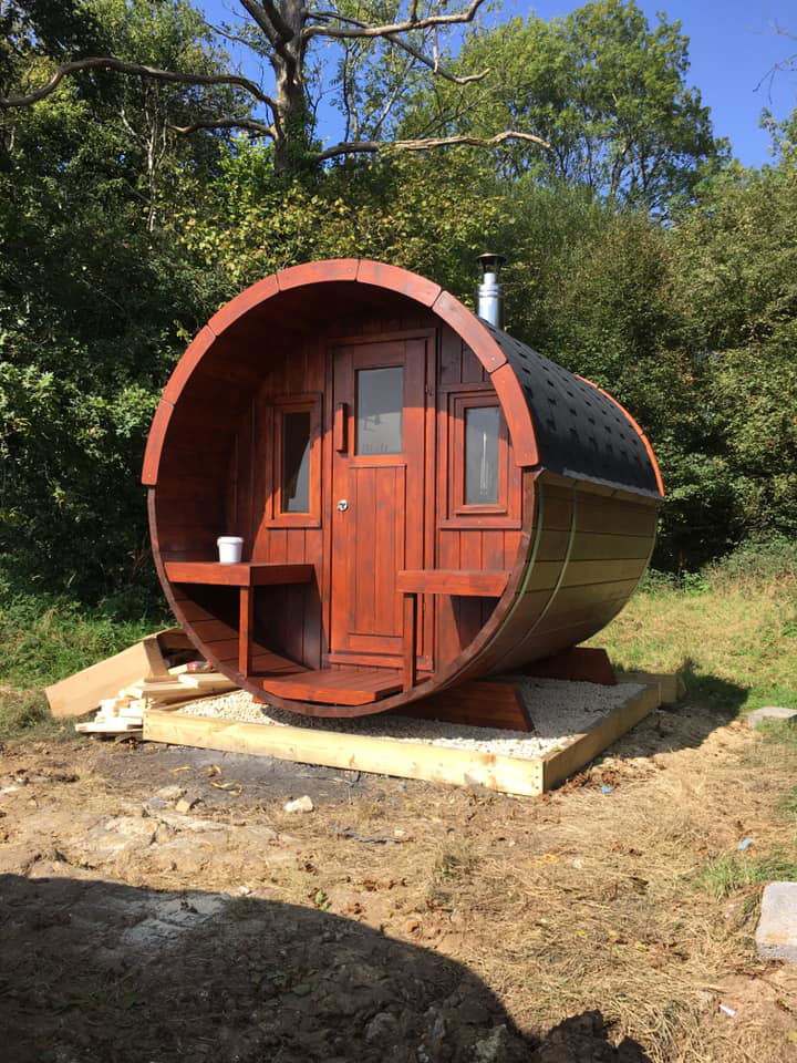 Saunamo Sauna extérieur Barrel 235 avec design cylindrique et terrasse intégrée.