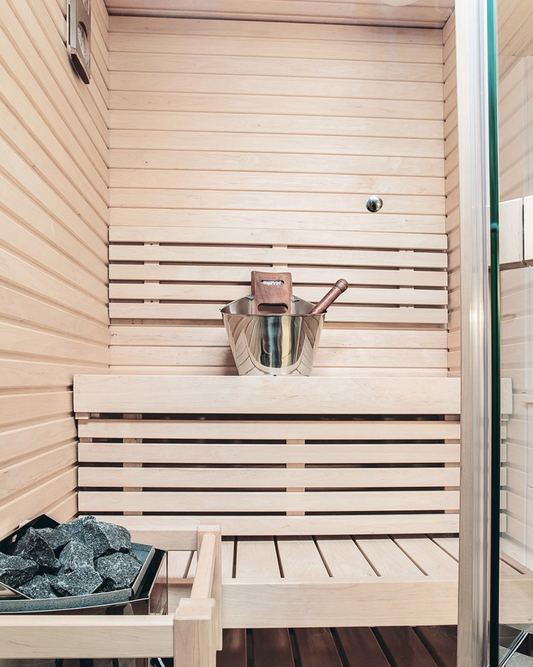 Sauna Sirius avec seau et pierres.