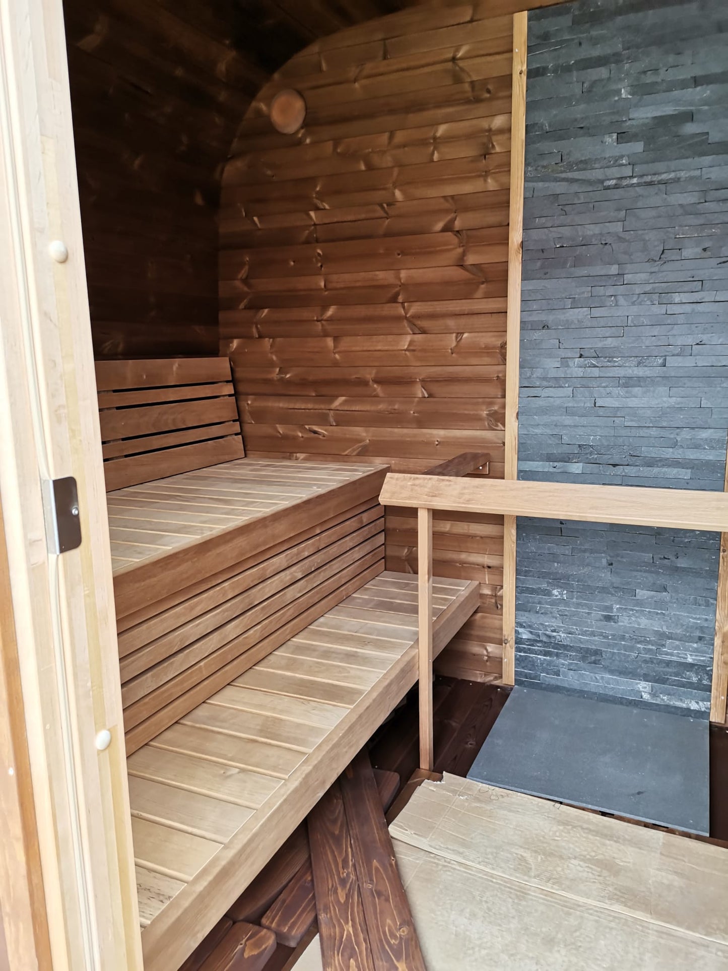 Saunamo Sauna Cubus avec mur partiel en pierre.