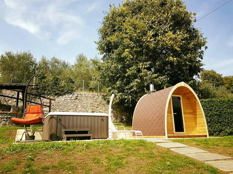 Saunamo Pod à côté d'une cabane en bois et d'un jardin.