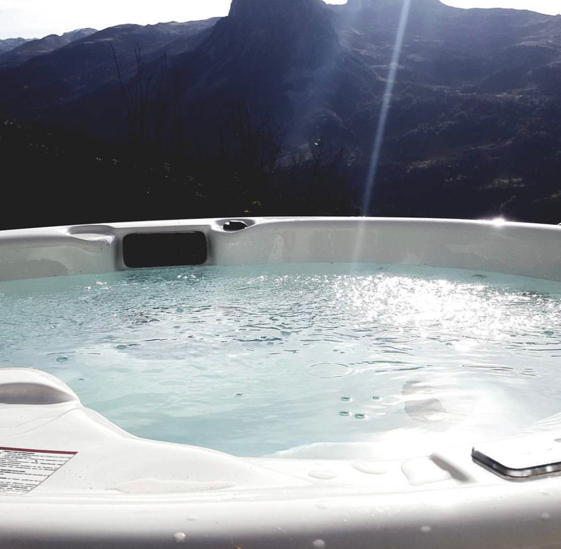 Saunamo Bain hydromassant Serena 210 avec vue sur les montagnes.